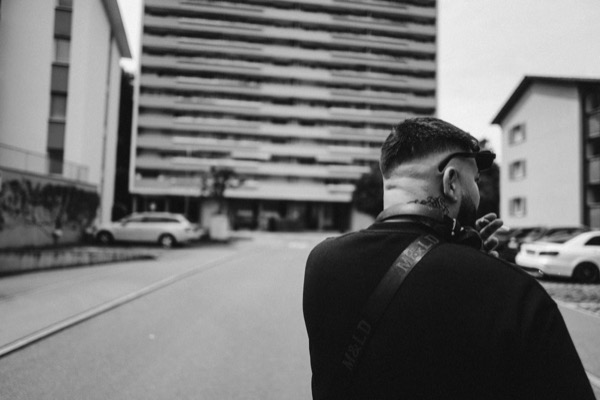 GABU im Profil vor einem Hochhaus, Schwarzweiss