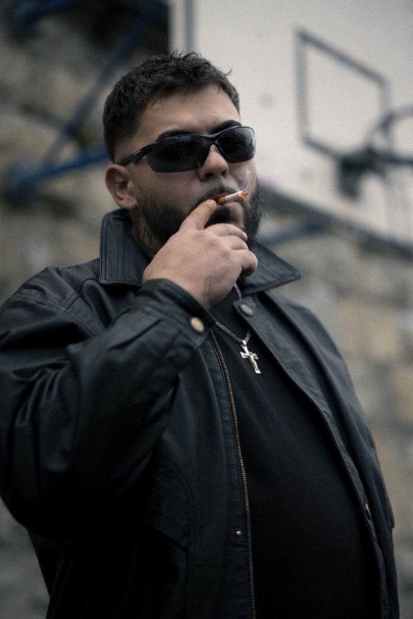 GABU mit Sonnenbrille und Zigarette vor einem Basketballkorb