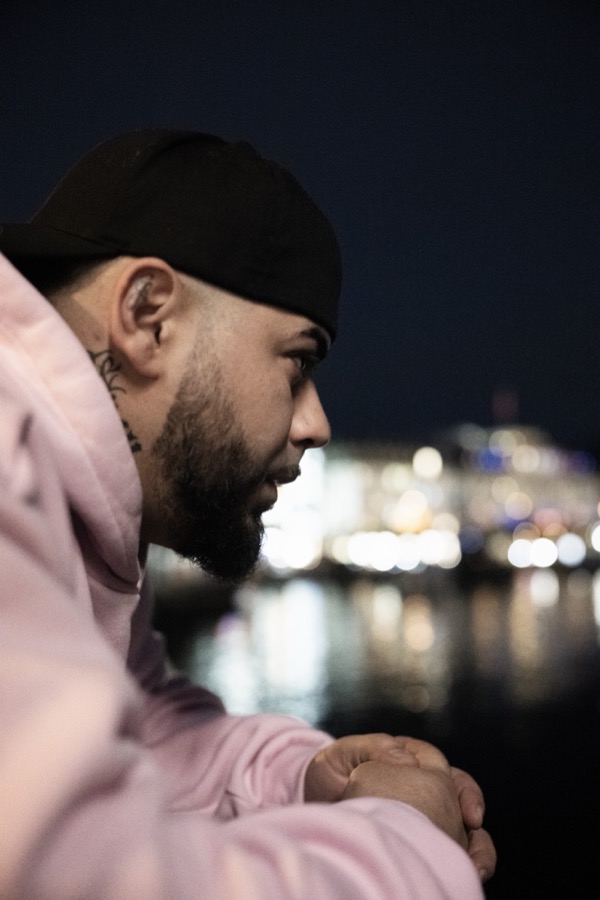 GABU im rosa Kapuzenpullover bei Nacht, Lichter im Hintergrund